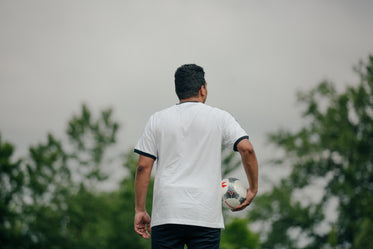 soccer player holding ball looking out
