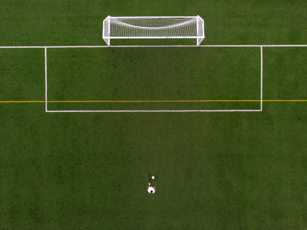 soccer player in penalty kick position drone view