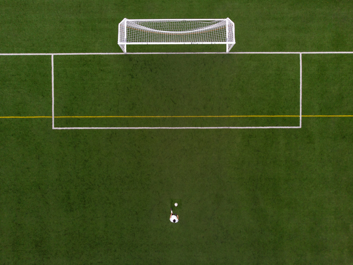 soccer player in penalty kick position drone view