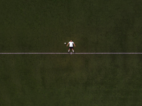 soccer player laying in the center line