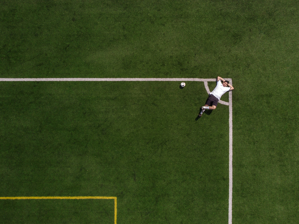 jogador de futebol relaxando no canto do campo