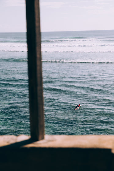 solitary surfer paddles out to the waves