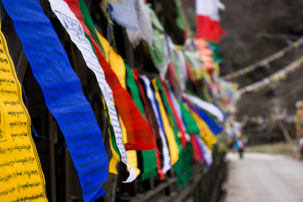 some colorful flags line a fence