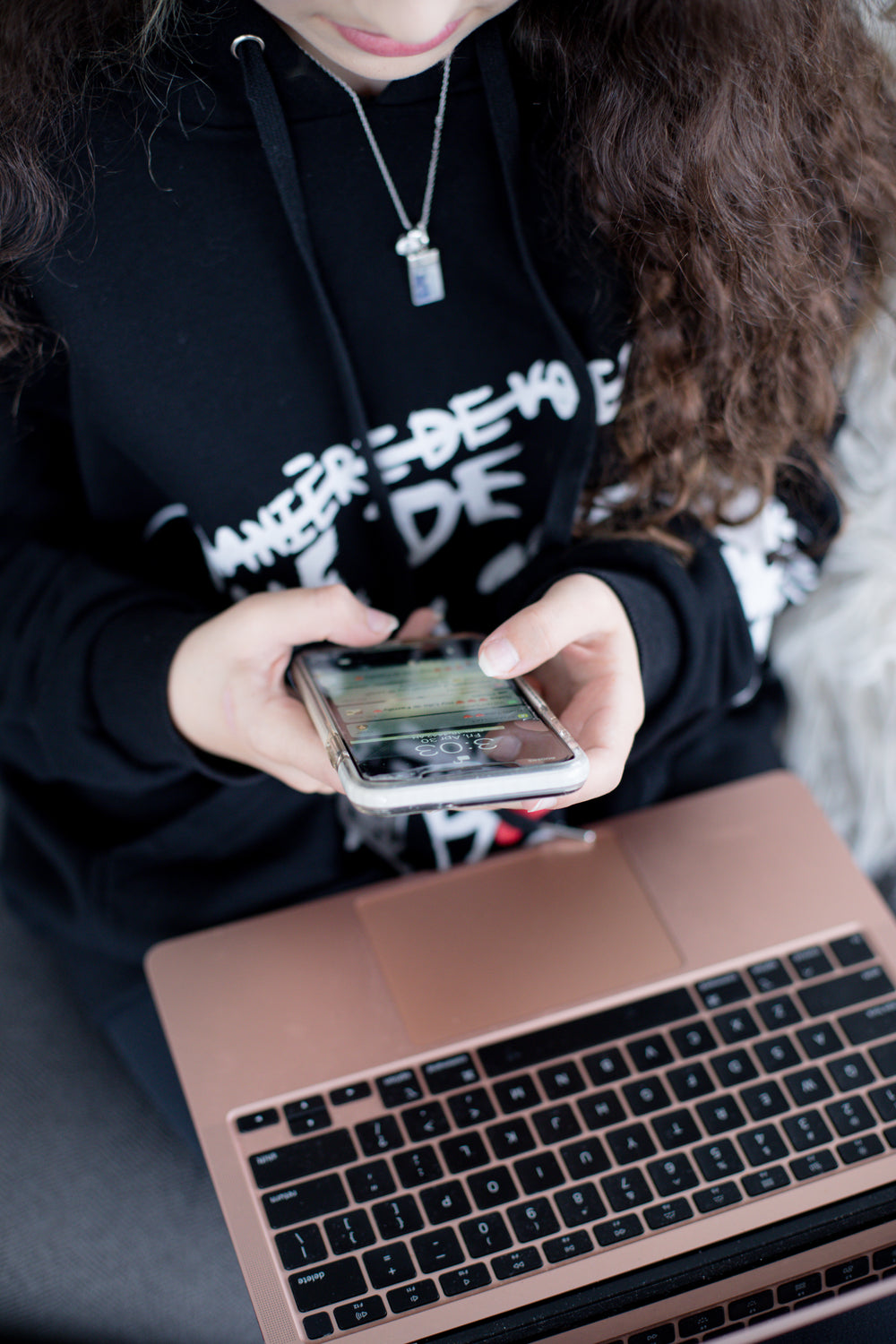 someone holding their phone over a laptop keyboard