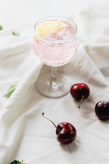 sparkling drink and cherries on fabric