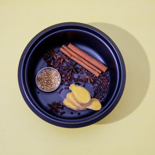 spices lay in a blue bowl against a yellow background
