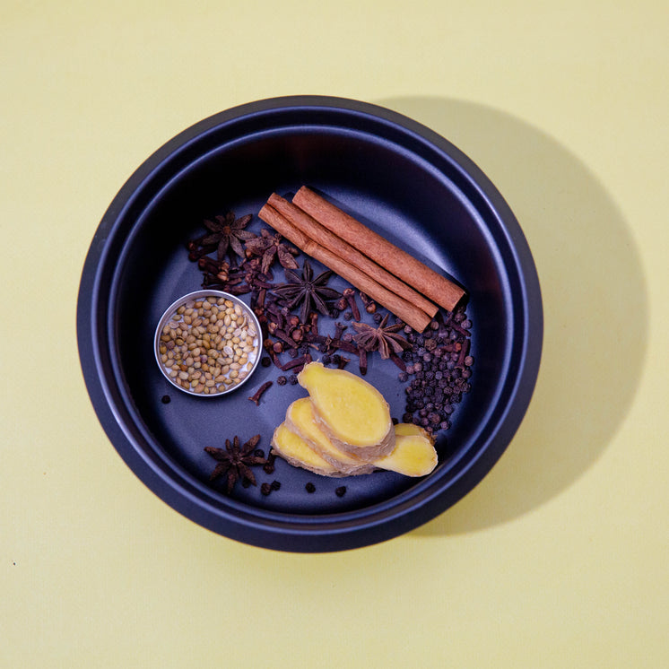 Spices Lay In A Blue Bowl Against A Yellow Background