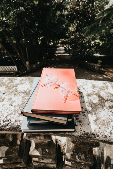 stack of books with a pair of glasses on top