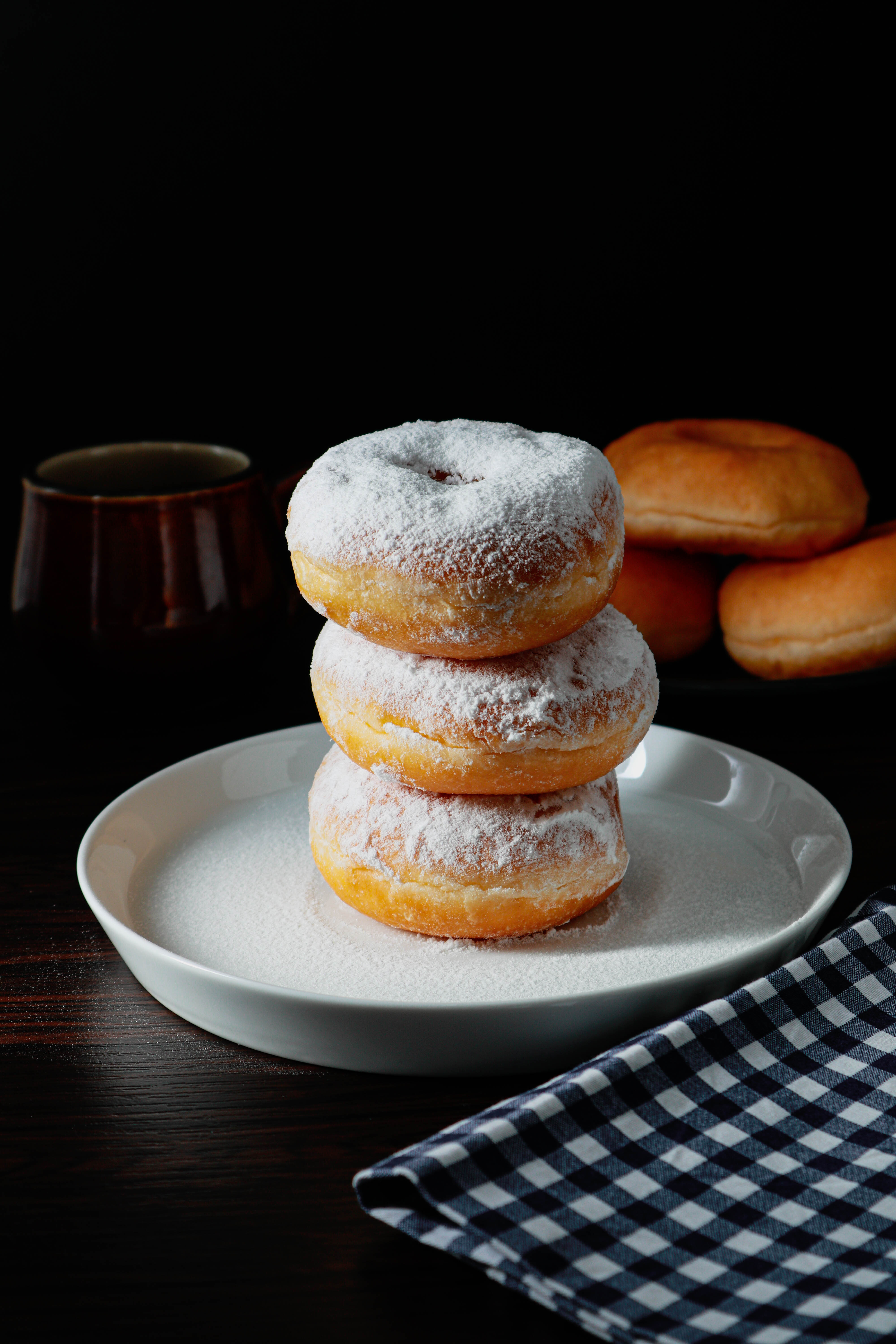 Stack Of Doughnuts With White Powered Tops On A Plate