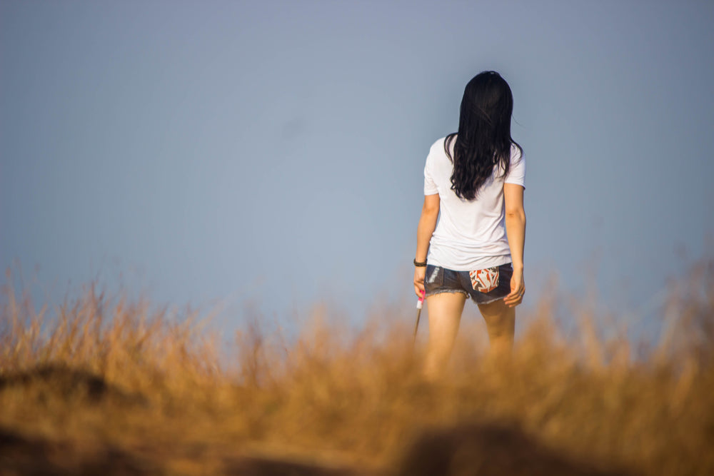 standing in tall brown grass away from the camera