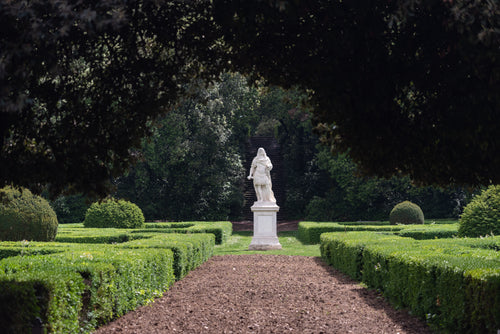 statue in centre of lushly groomed garden