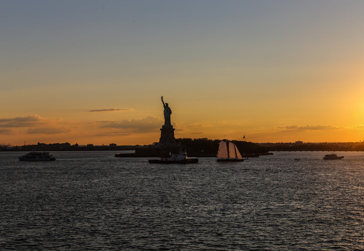 statue of liberty lit by sunset