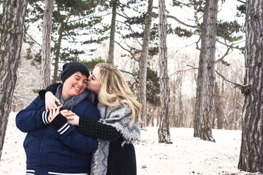 stealing a kiss on a winter stroll through the woods