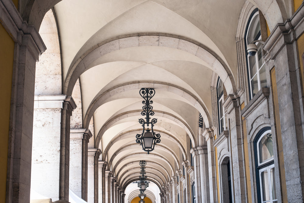 stone arches line a hallway dotted with iron lanterns