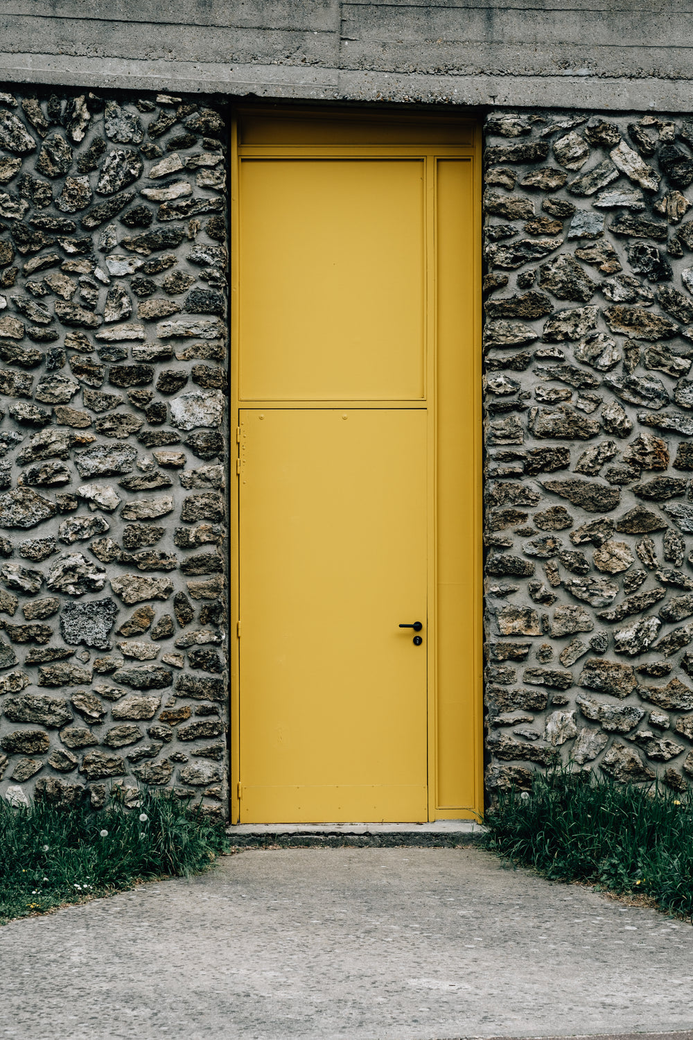 stone building with a thin bright yellow door