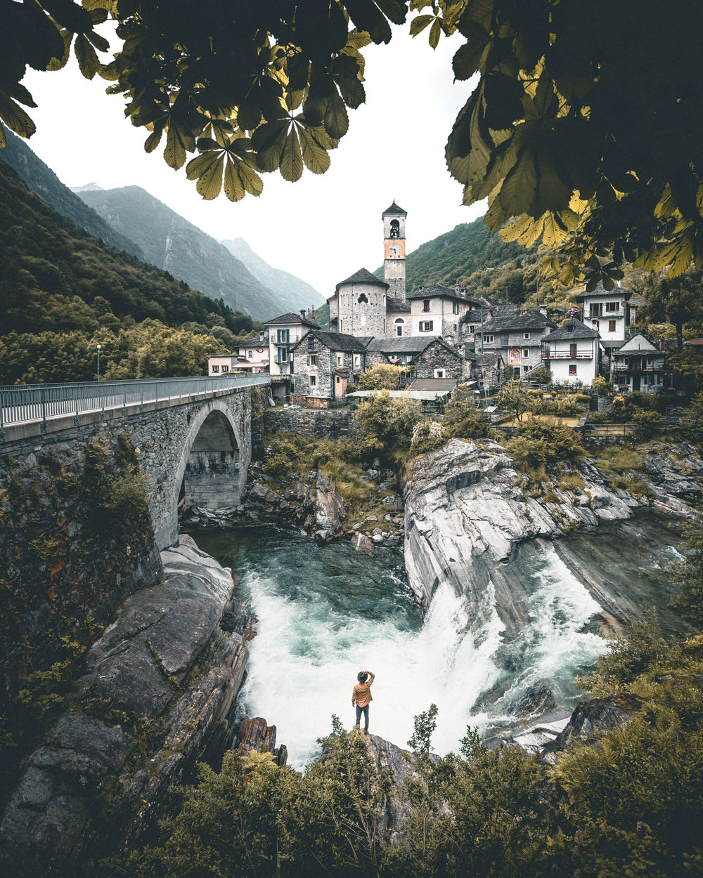 stone buildings built at the side of waterfall