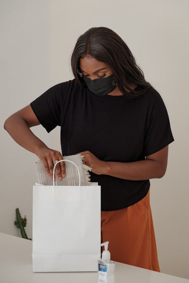 store owner packs a bag for her customer