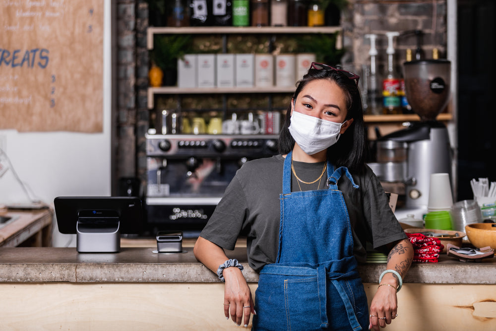 store owner stood wearing her face mask