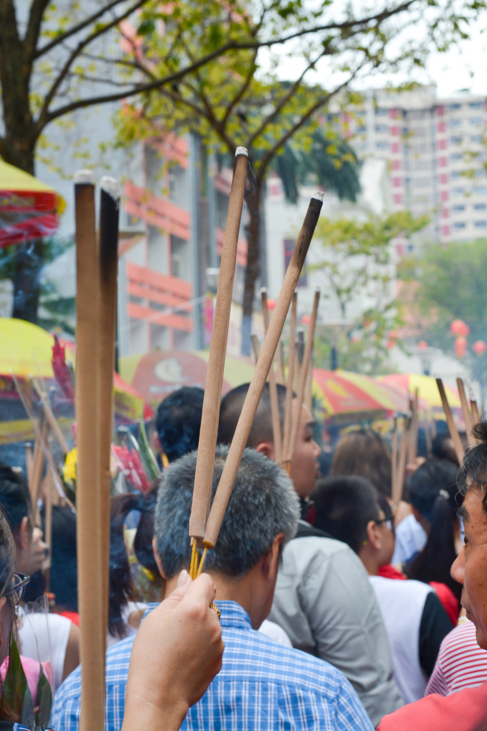 street full of people holding long sticks with burnt ends