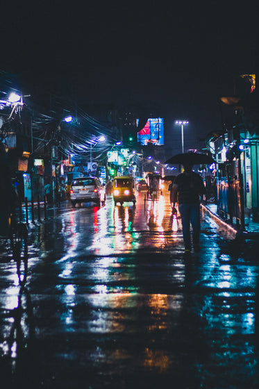 street lights reflect on wet city streets in india