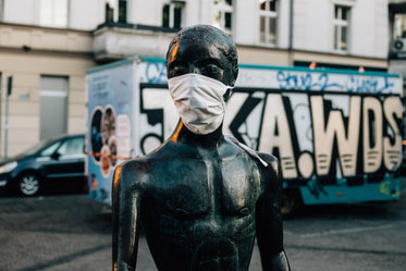 street scene of statue wearing mask