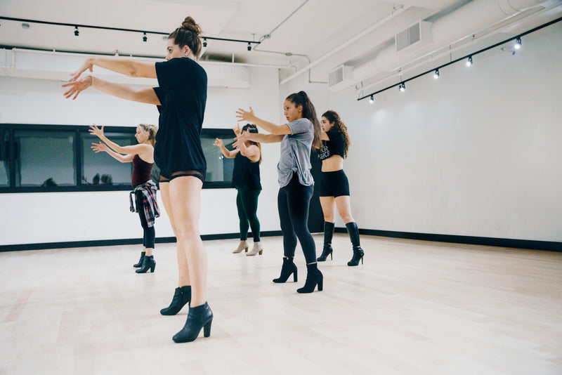 Dancers rehearsing in a mirrored studio