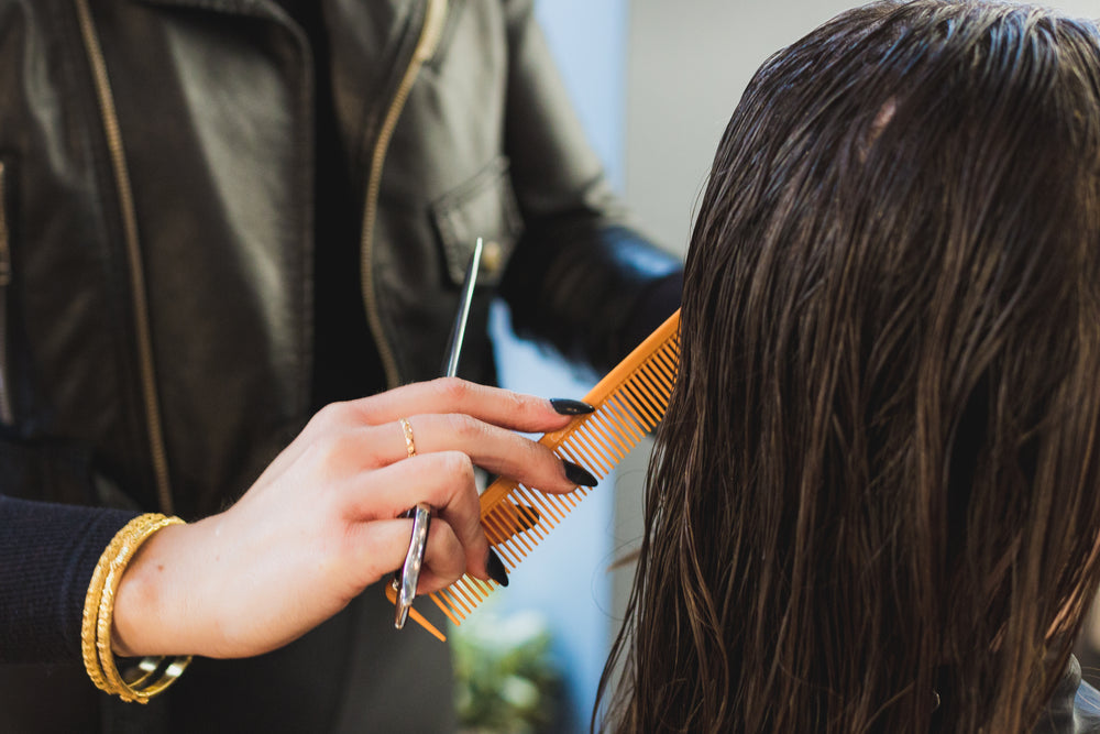 stylist combing brown hair