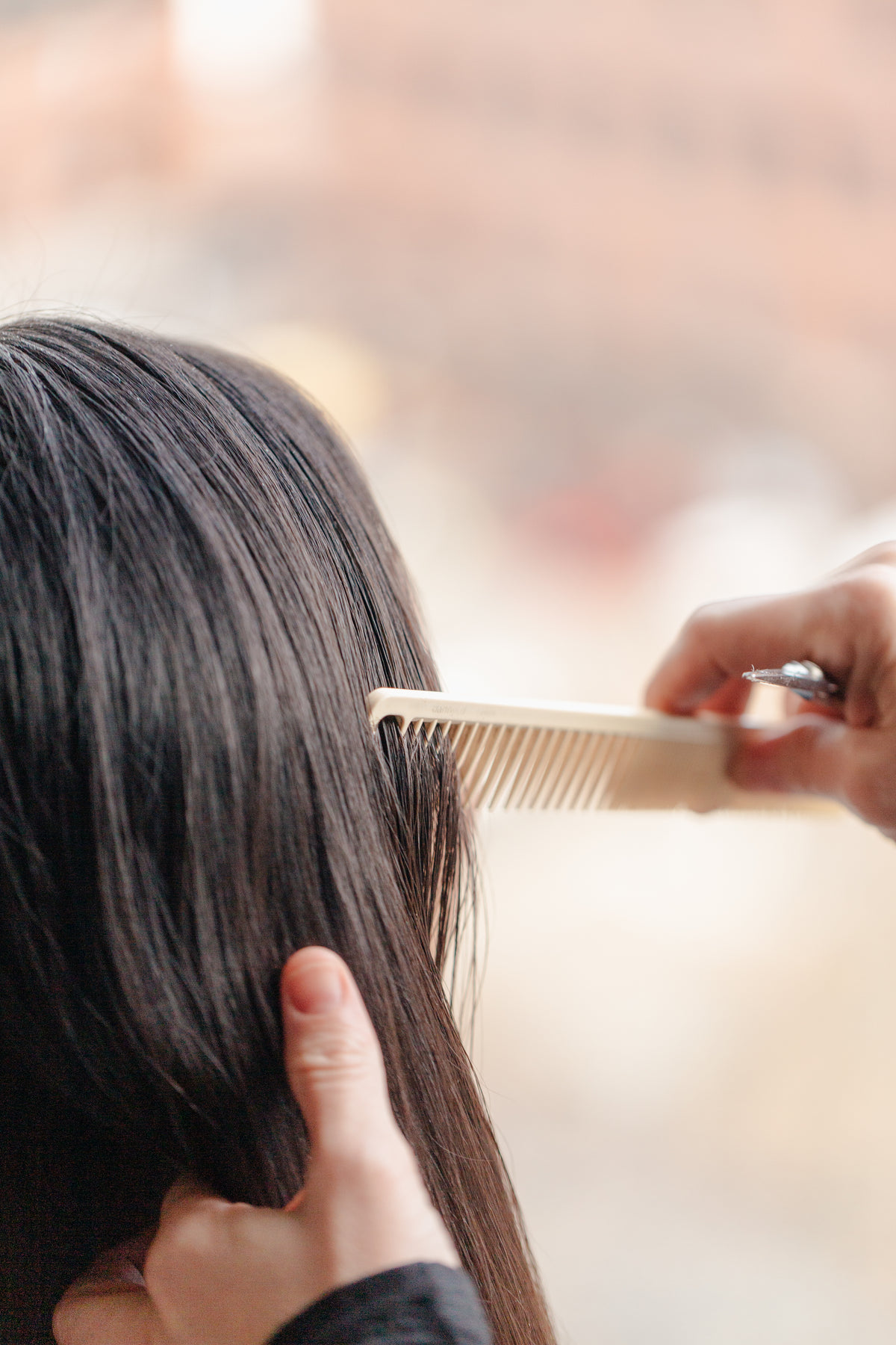 stylist combing through hair