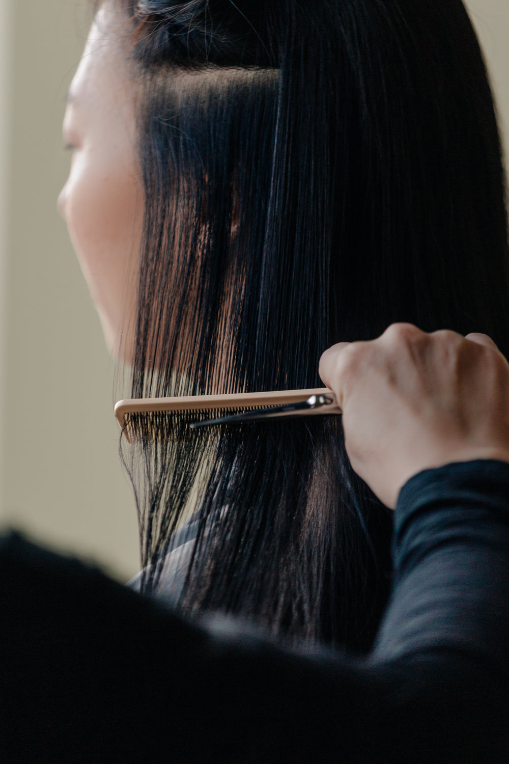 stylist combs through long hair