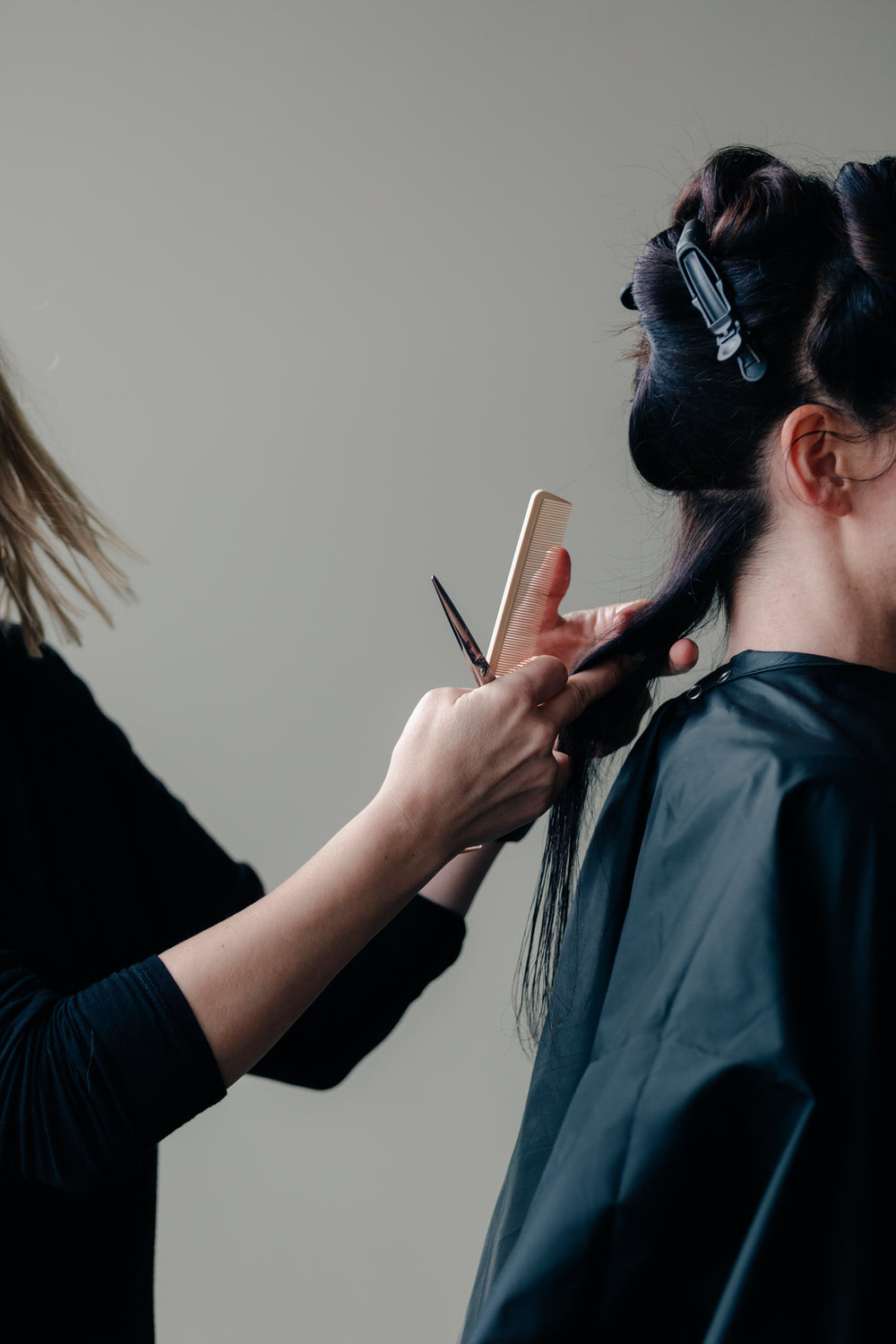 stylist cuts a woman's hair