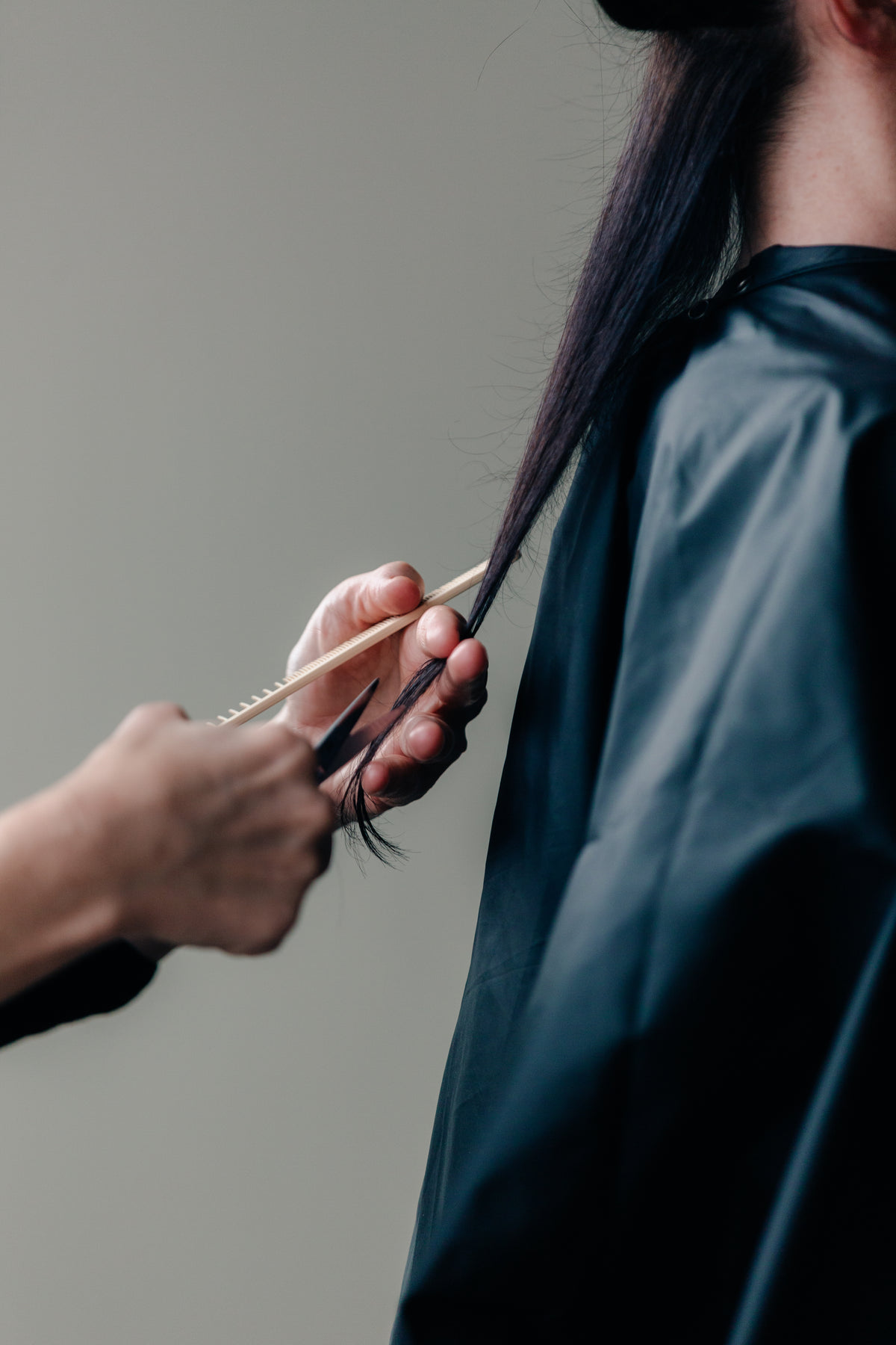 stylist cuts woman's long hair