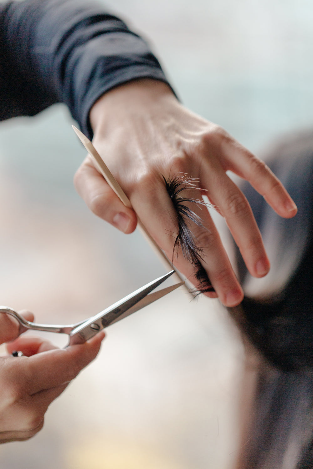 stylist trimming a woman's hair