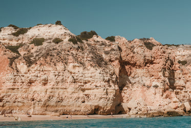 sun baked cliffs tower over sandy beach