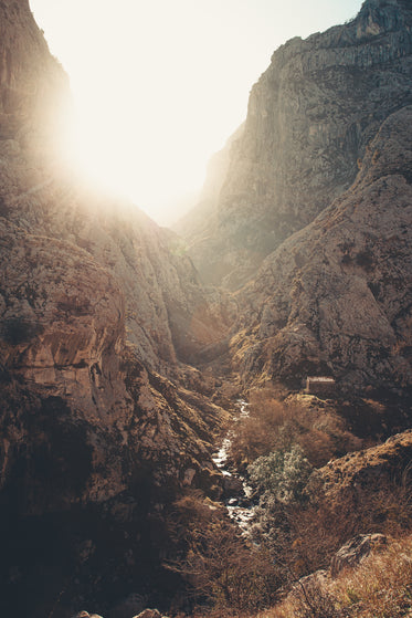 sun peaking through some mountain peaks