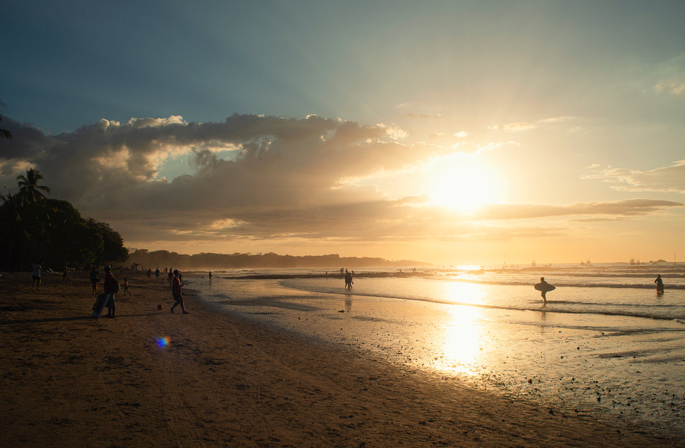 sun sets in the distance and shines on the water