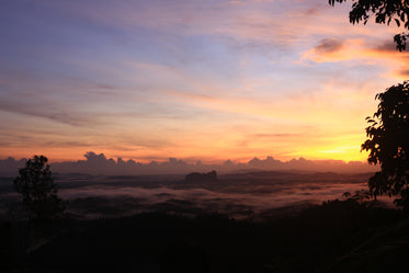 sun sets over a cloudy sky