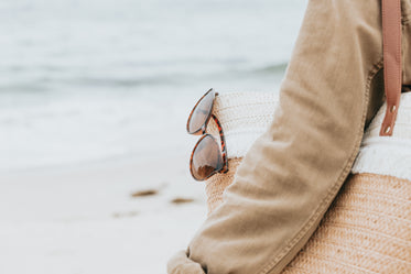 sunglasses hanging from the side of a beach bag