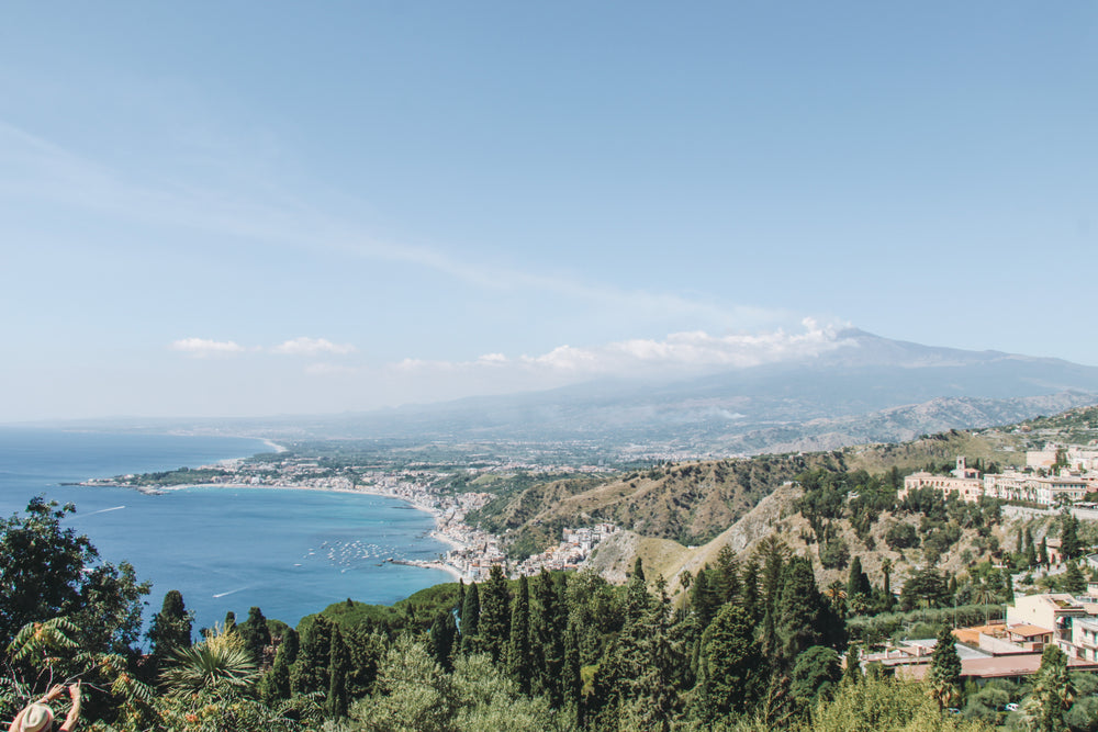 sunny coastline below distant mountains