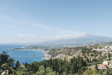 sunny coastline below distant mountains