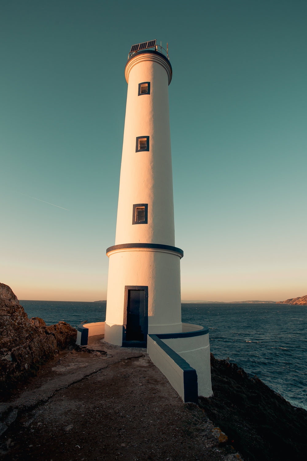 sunset casts shadows on lighthouse