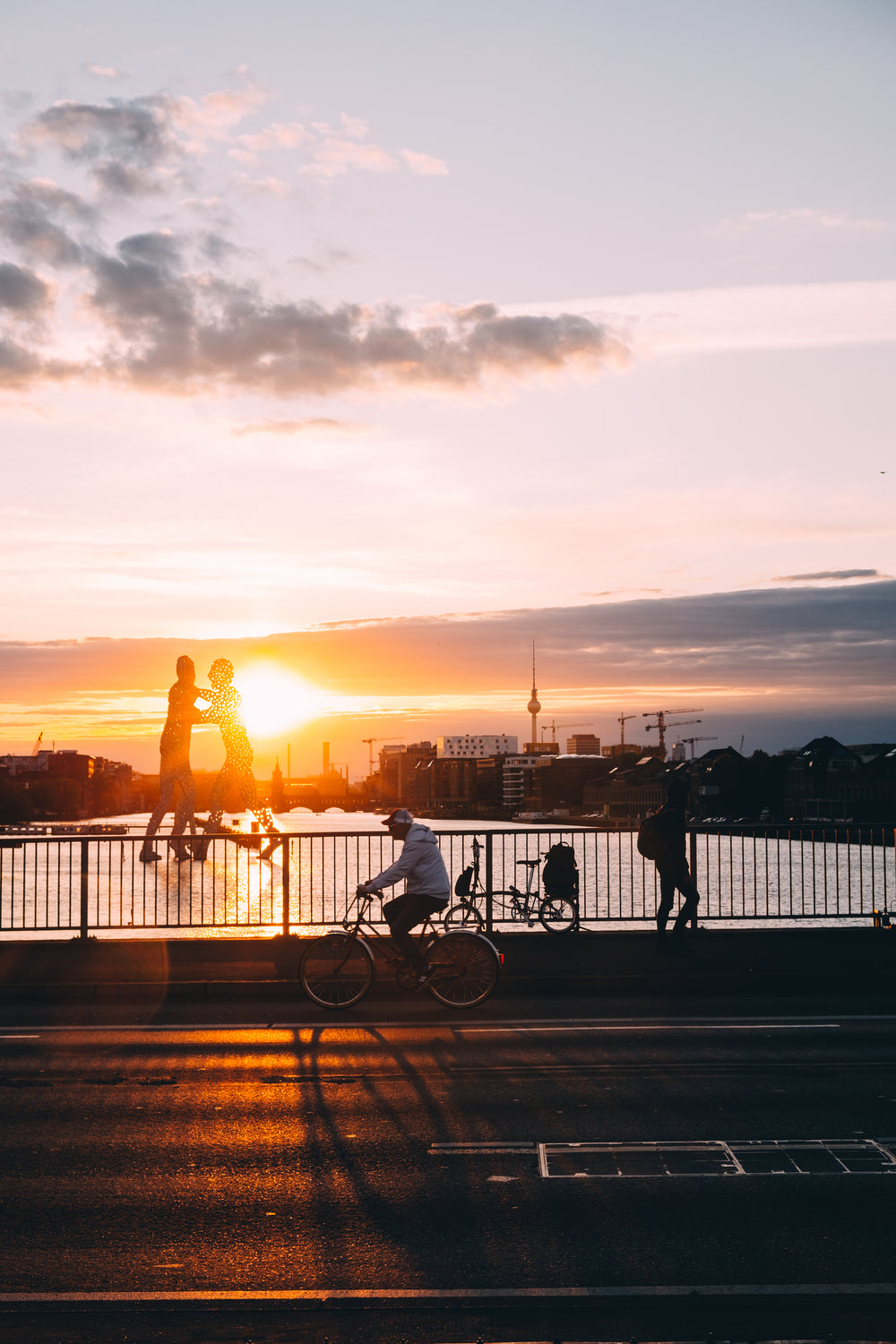 sunset glares over water by a bridge