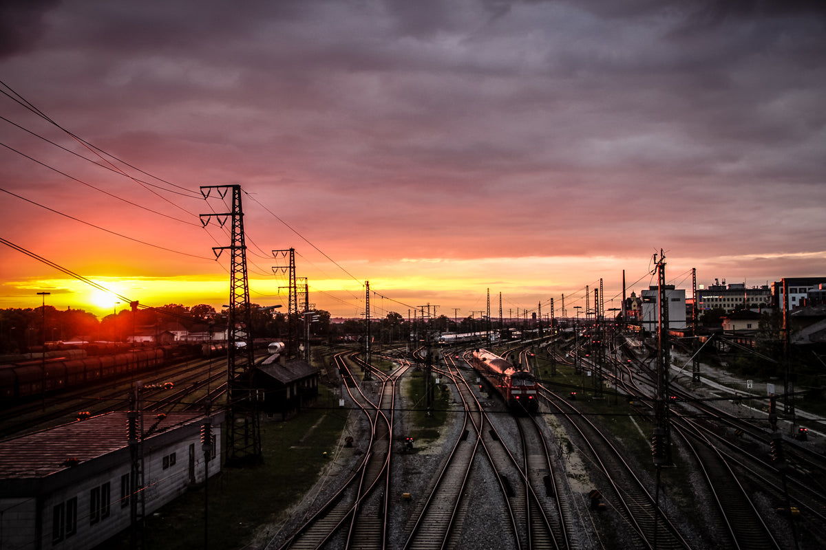 sunset over a hub of winding train tracks
