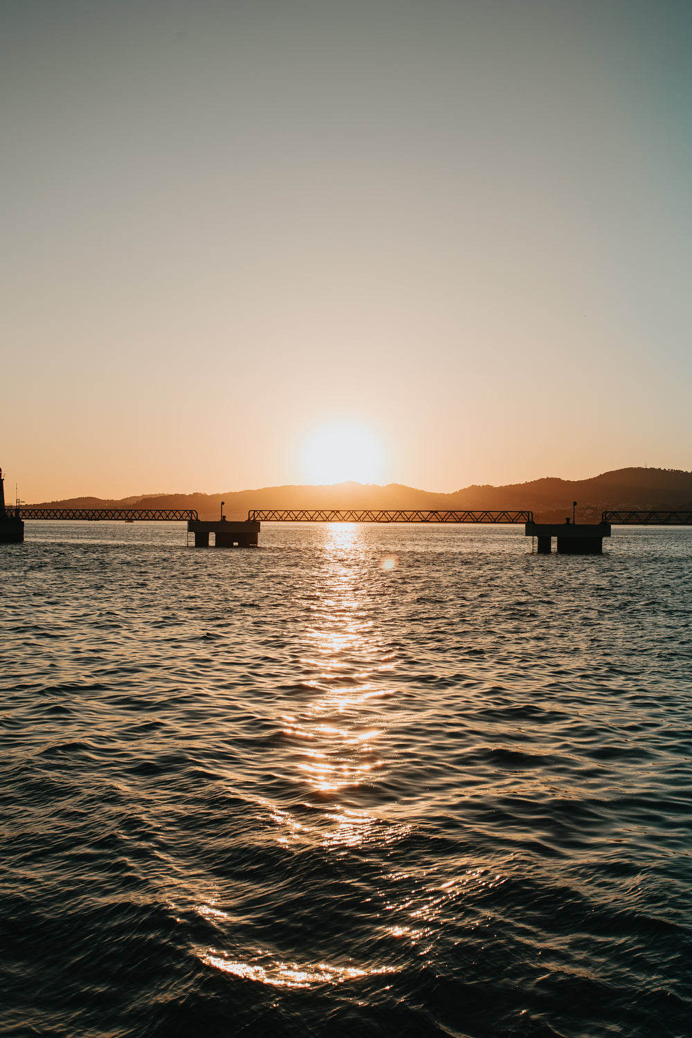 sunset over an industrial bridge