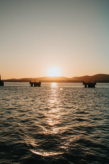 sunset over an industrial bridge