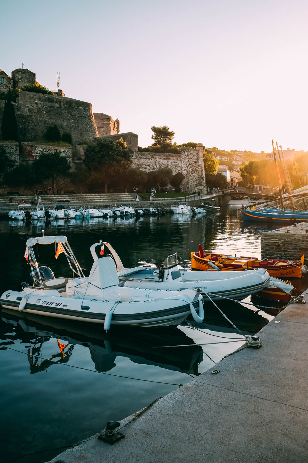 sunset over bastions and boats of a marina