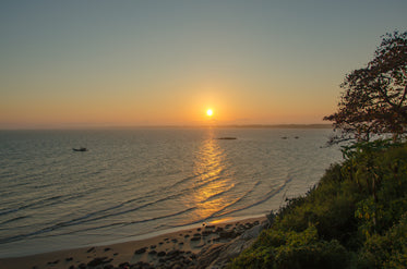 sunset over calm water and sandy shore