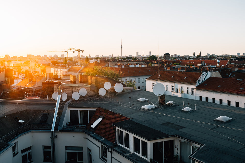 sunset over roof topped with satellites.