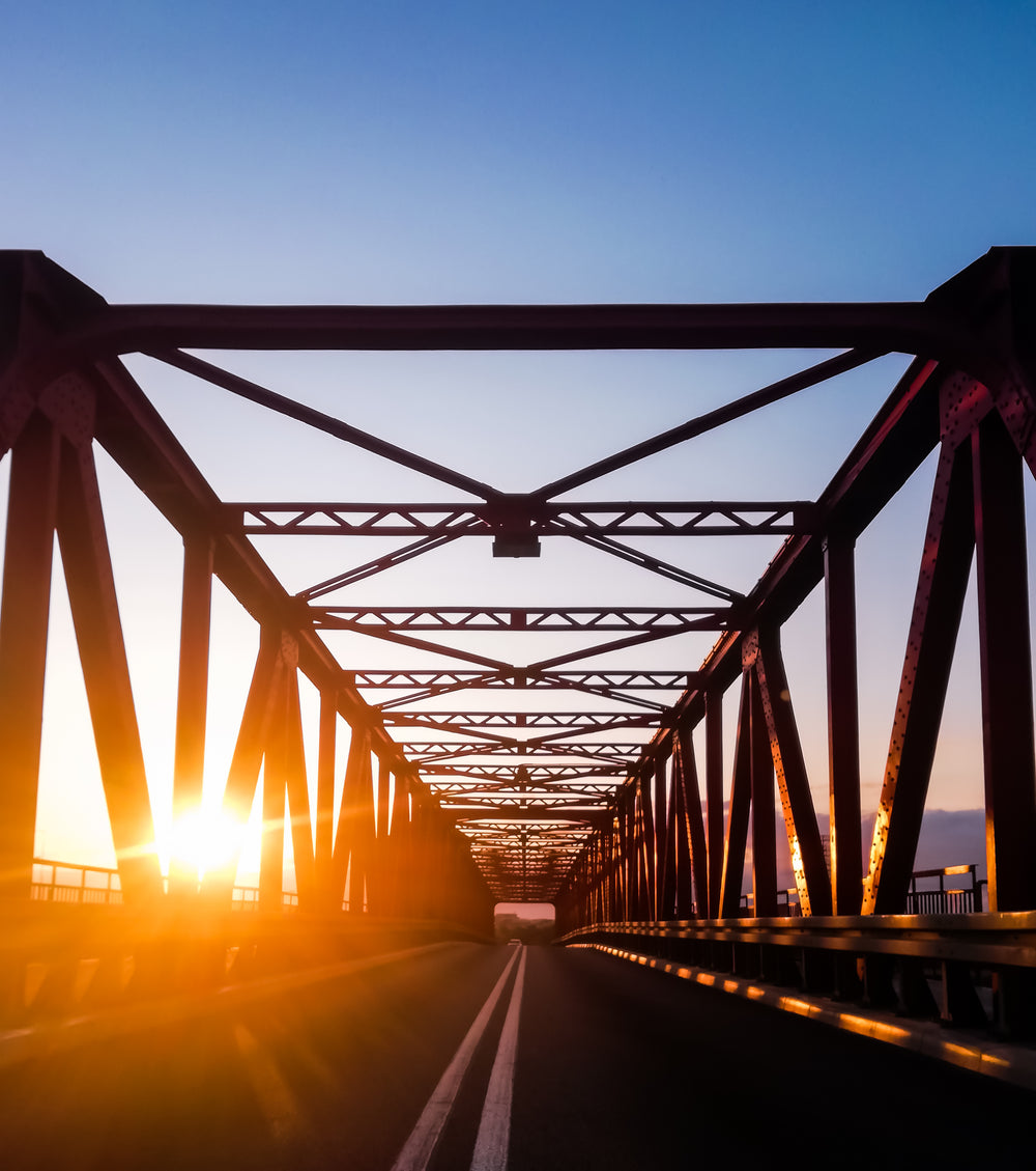 sunset view down a paved bridge road