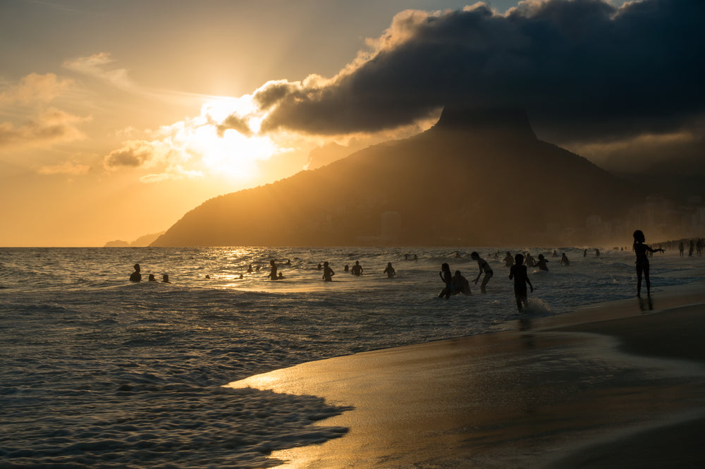 sunsets on a beach with people swimming