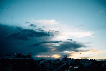 sunsets over a city as storm clouds move in